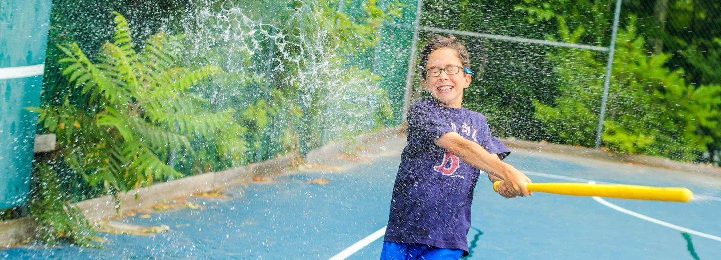 Boy hitting water balloon with bat