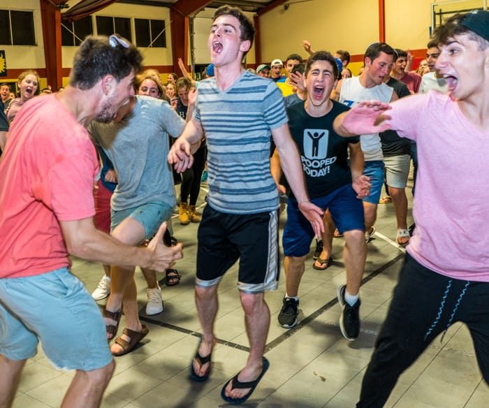 Campers celebrating and dancing indoors