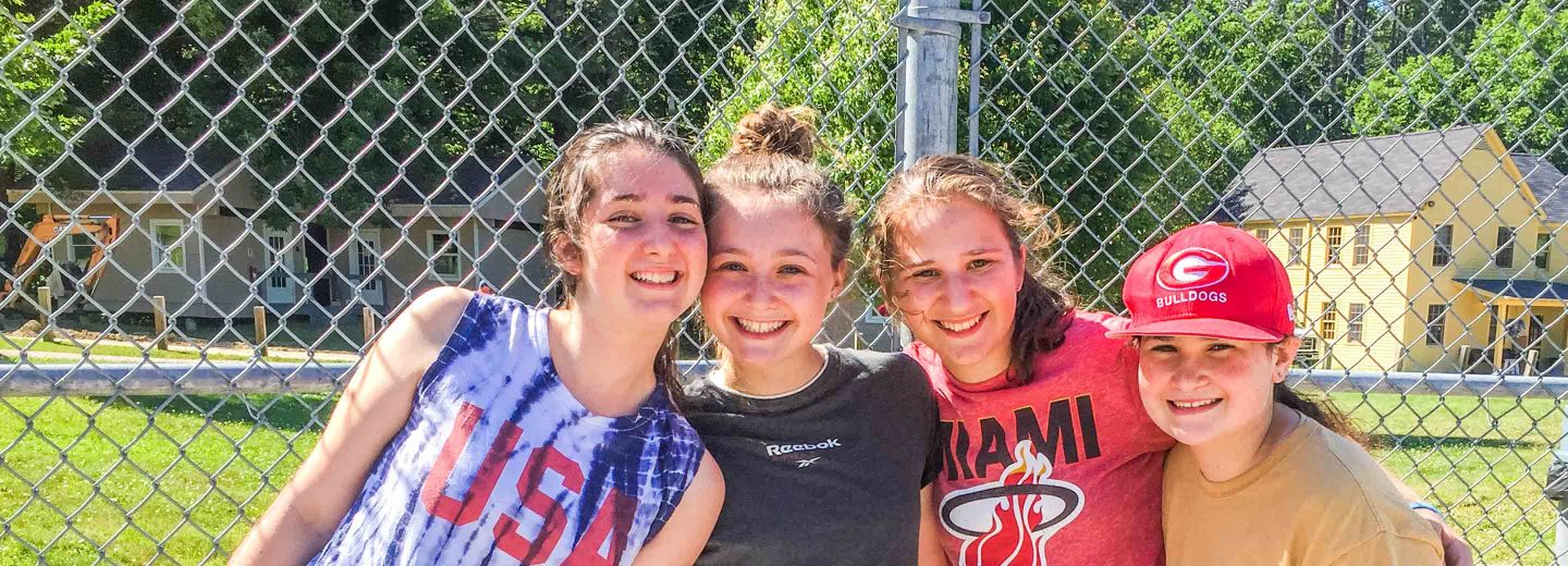 Girl campers near sports fence