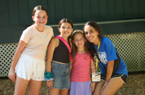 Counselor and three students smiling together.