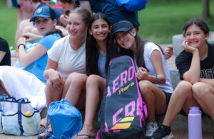 Group of students hanging out on a grassy lawn.